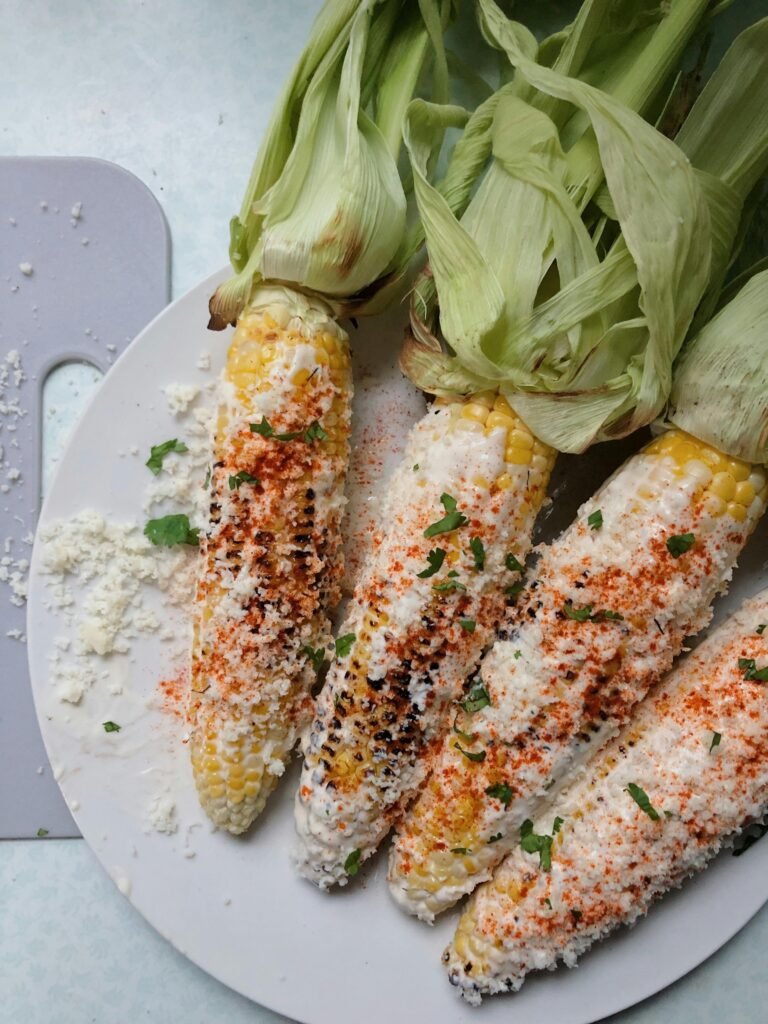 Close-up of seasoned Mexican street corn with cheese and chili flakes.