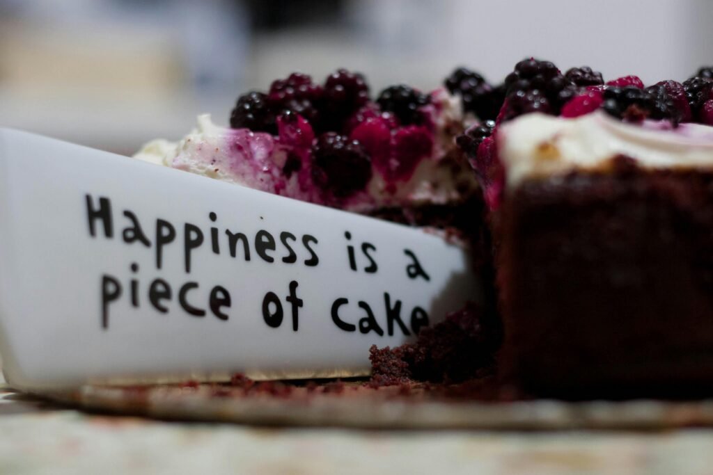 pexels-photo-227432-227432 Slice of berry-topped cheesecake with a message plate saying 'Happiness is a piece of cake'.