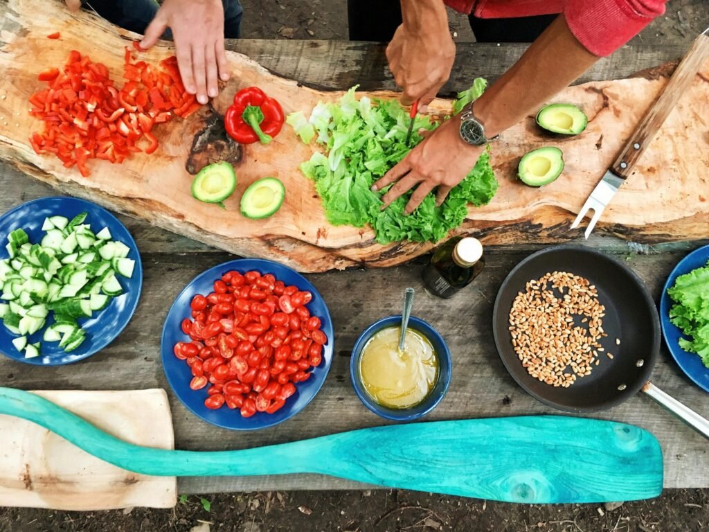 pexels-photo-2284166-2284166 Fresh ingredients being prepared on a rustic wooden table, showcasing vibrant vegetables and hands at work.