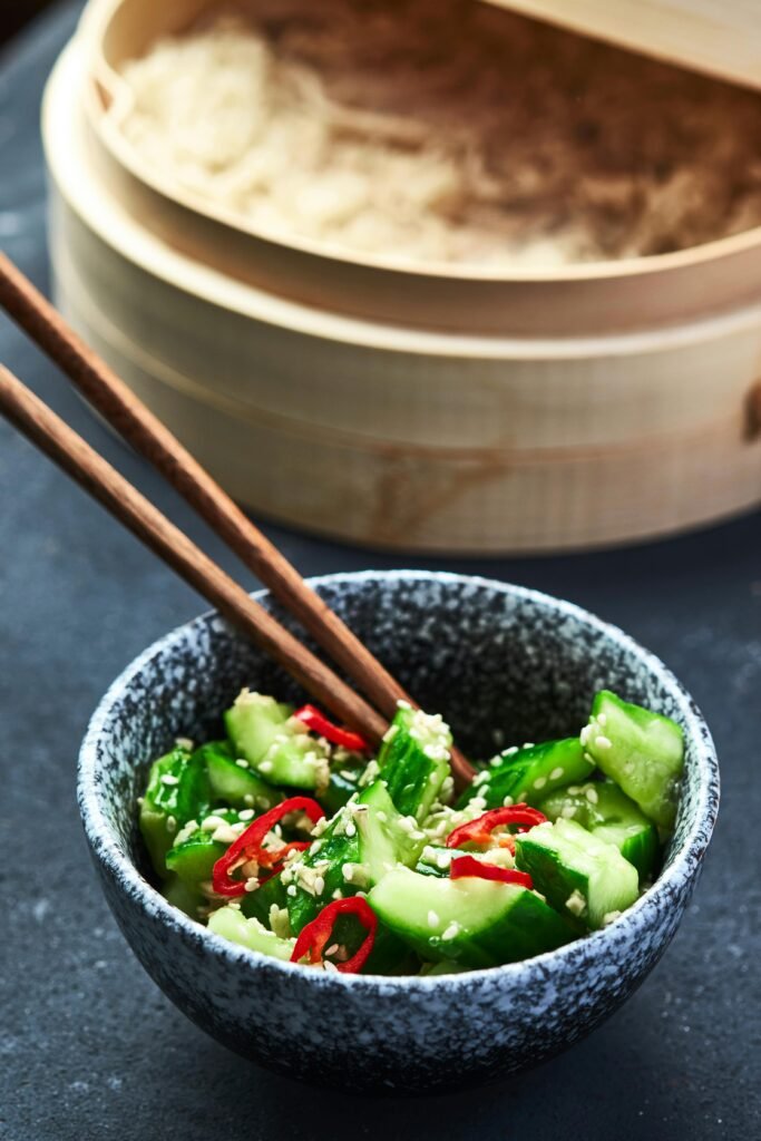 pexels-photo-12077975-12077975 Crisp cucumber salad with chili and sesame in a stoneware bowl, perfect for an Asian-inspired meal.