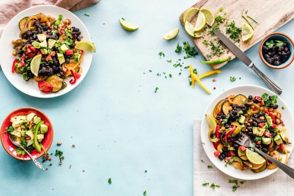 pexels-photo-1640774-1640774 Colorful Mexican salad with avocado, black beans, and lime on a light blue surface.