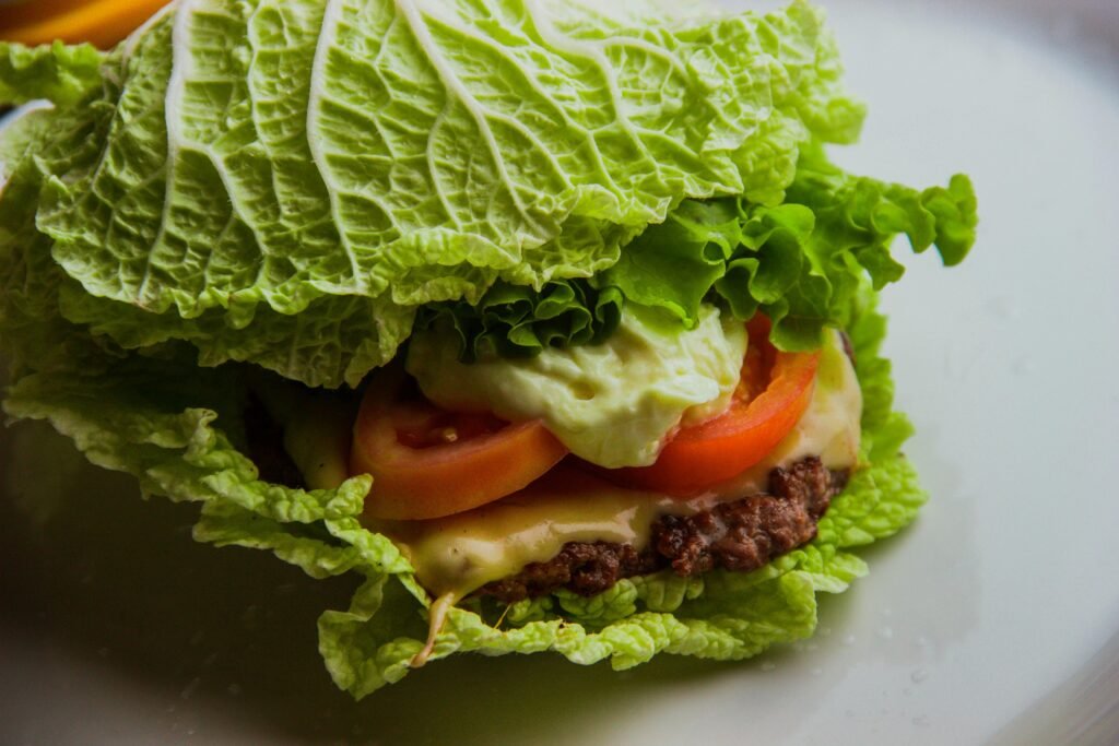 Close-up of a nutritious lettuce-wrapped burger with fresh ingredients.