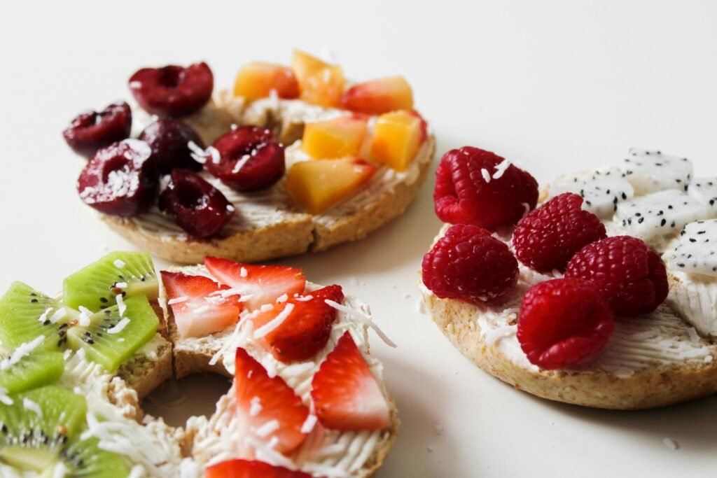 pexels-photo-946543-946543 Vibrant and fresh fruit-topped bagels featuring kiwi, strawberries, raspberries, cherries, and more.