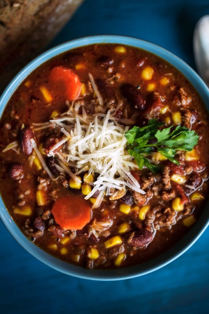 Delicious homemade beef chili served with fresh bread on a rustic table for a cozy meal.