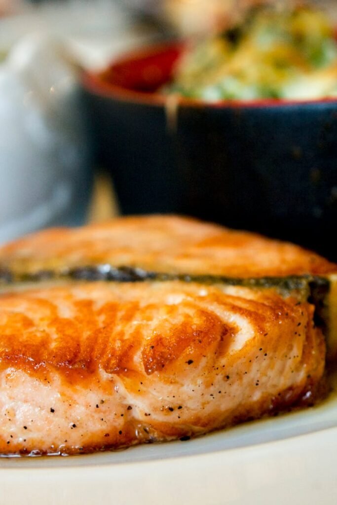 Delicious pan-seared salmon steak garnished with a lemon slice, showcasing a perfect dining experience.