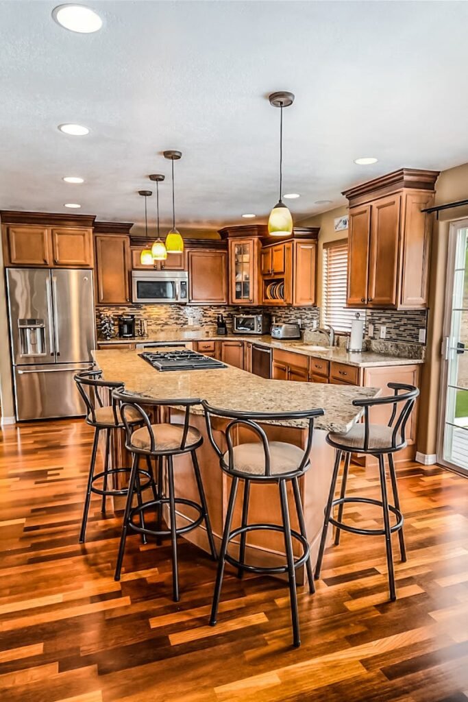 A luxurious modern kitchen featuring hardwood floors and granite countertops.