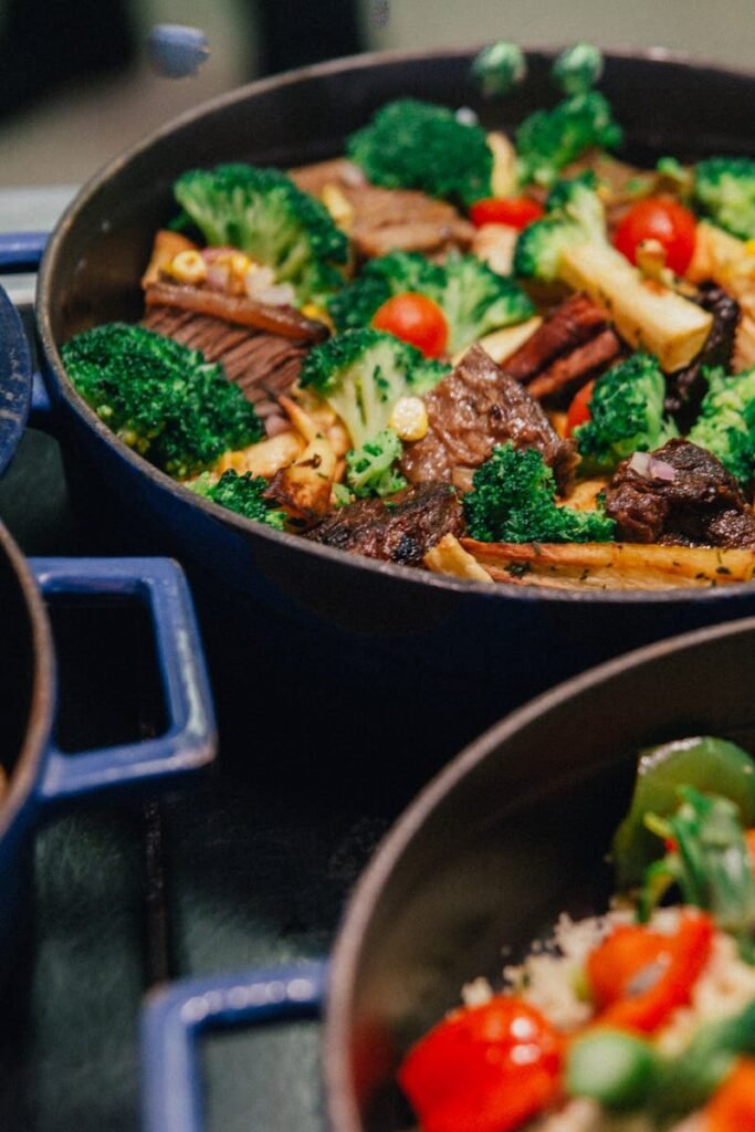 Vibrant stir-fried beef with broccoli, tomatoes, and peppers in blue pots.