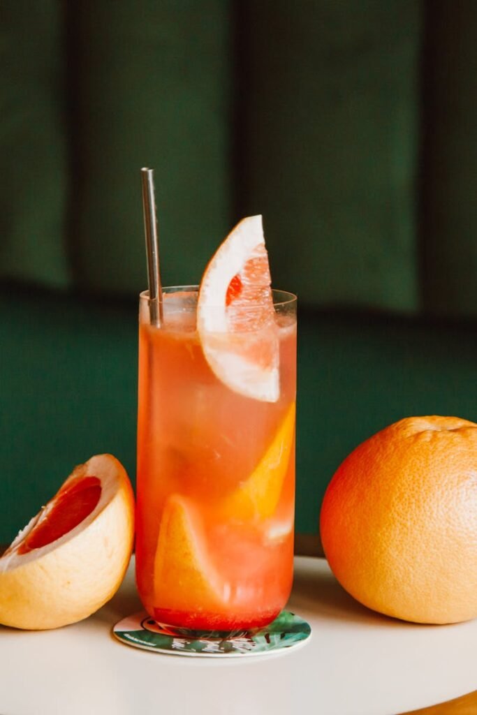 pexels-photo-7494029-7494029 Glass of grapefruit cocktail with fresh slices on table, ideal for refreshing summer drinks.